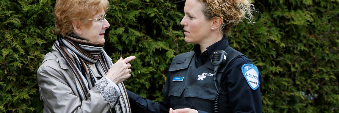 Policière discute avec une dame âgée
